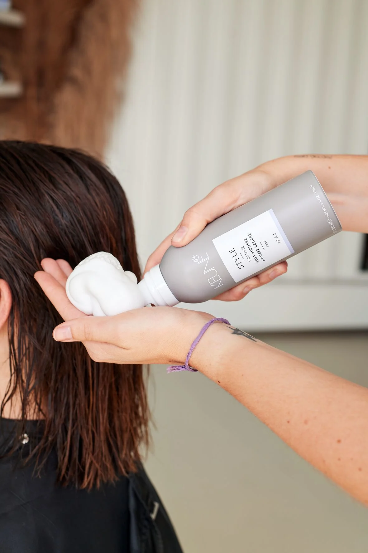 Image of hairstylist using Keune Style Soft Mousse